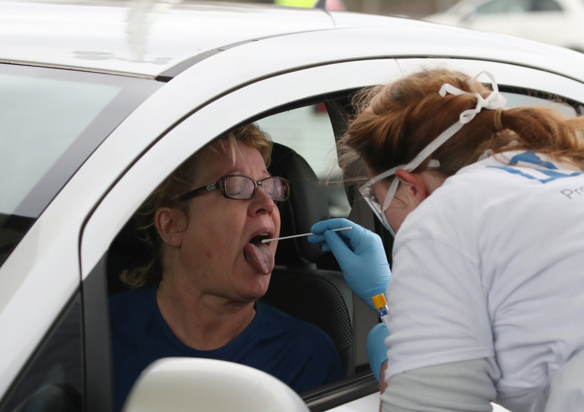 een vrouw test een bestuurder op het corona-virus