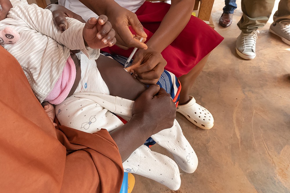 een kind krijgt een vaccin tegen malaria